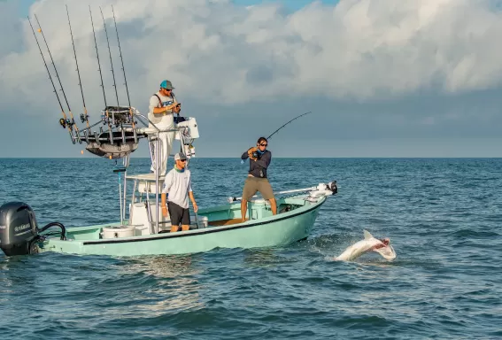 Men fishing reeling in tarpon